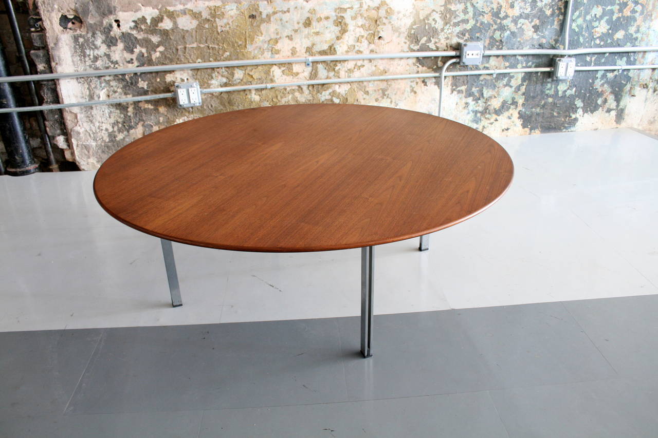 An early example of Florence Knoll's design. Four Steel and Aluminum legs cradle a round walnut top. An elegant and beautiful design.