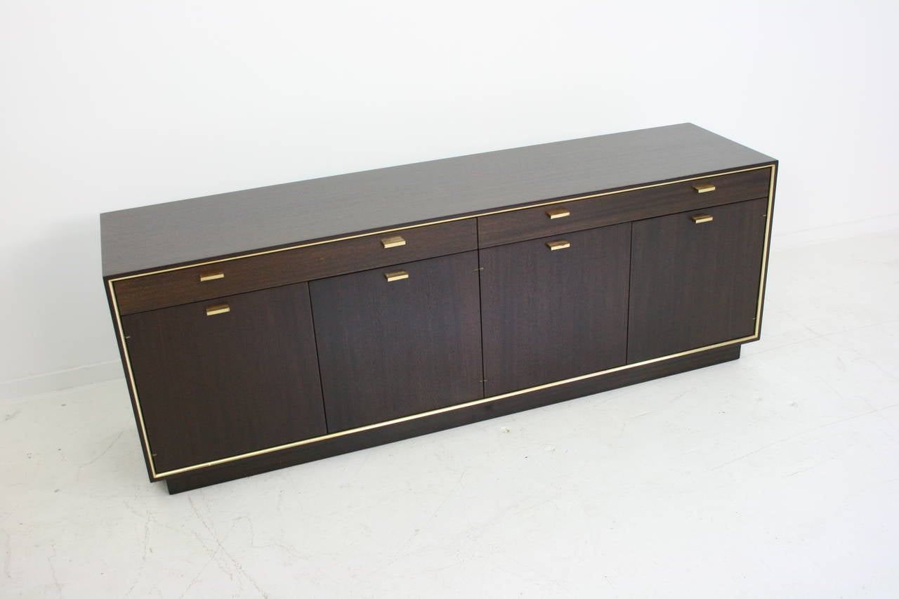 Harvey Probber sideboard freshly restored. Sideboard of dual-tone mahogany wood. Brass pulls and quarter round molding surround front door and drawer section. Four doors to reveal ample storage, with a pair of shelves and two large drawers for