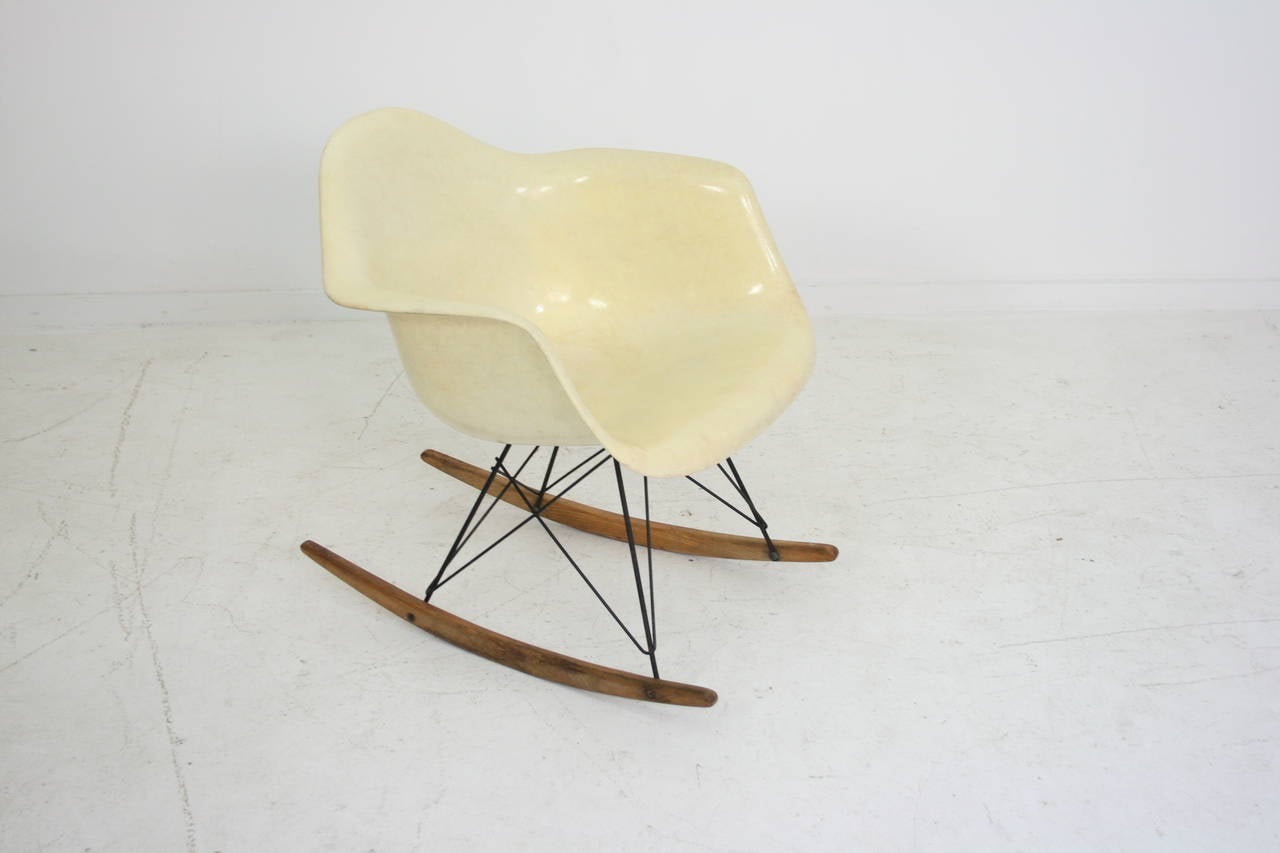 This rocker is all original. The parchment color shell has a rope edge and a checkerboard Zenith label. The black wire base has birch runners in fine original condition with a beautiful patina.