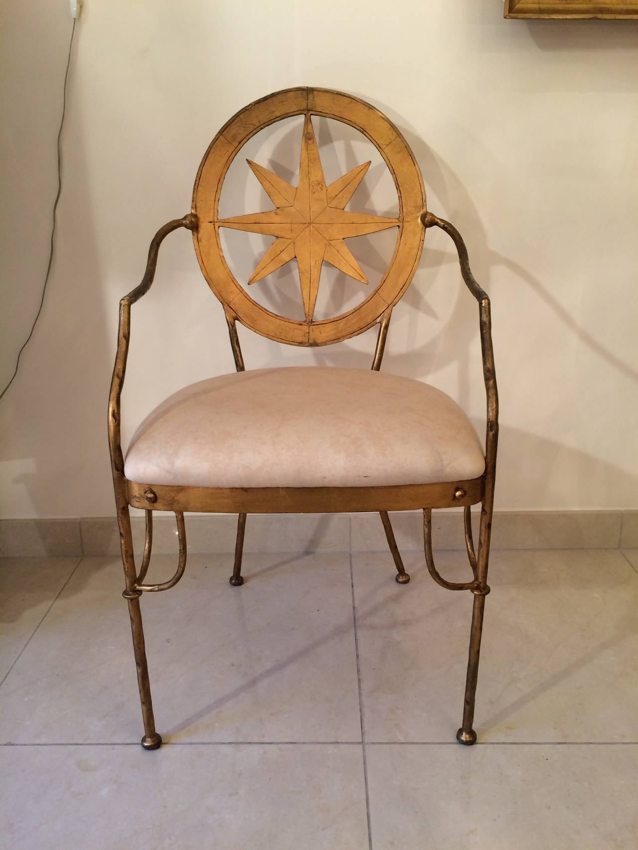 Pair of wrought iron armchairs, gold leaf patina. 
This pair is matching with a set of ten chairs of the same design.