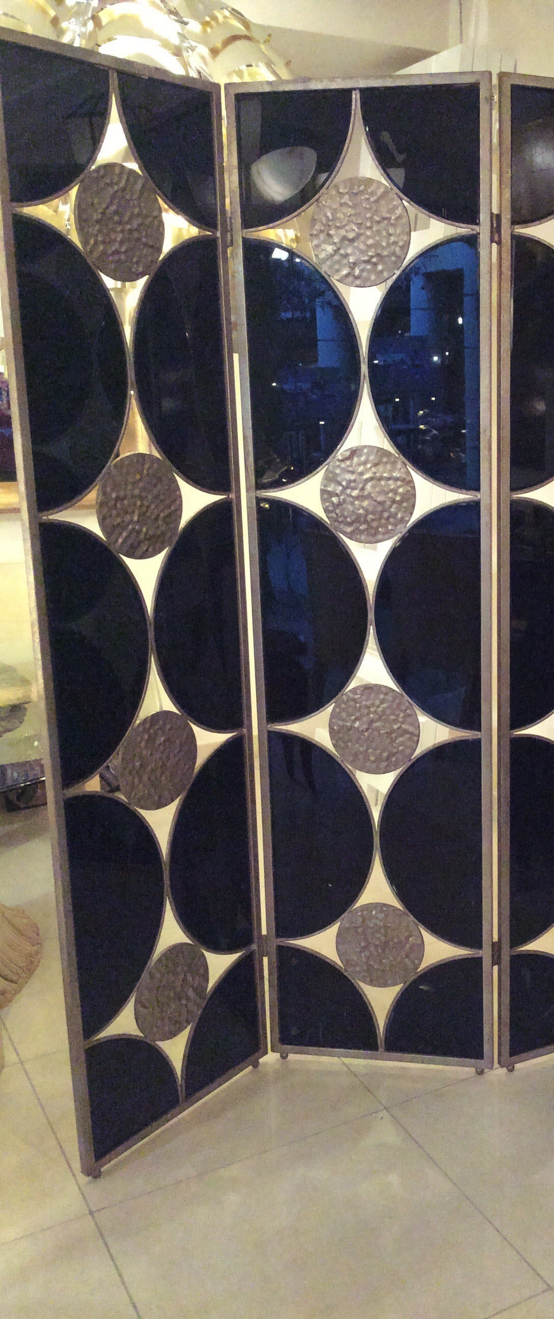 Very decorative screen in hammered  wrought iron and black mirror,4 pannels.
The 2 sides are different  with reverse  decor.
silver and gold  patine.