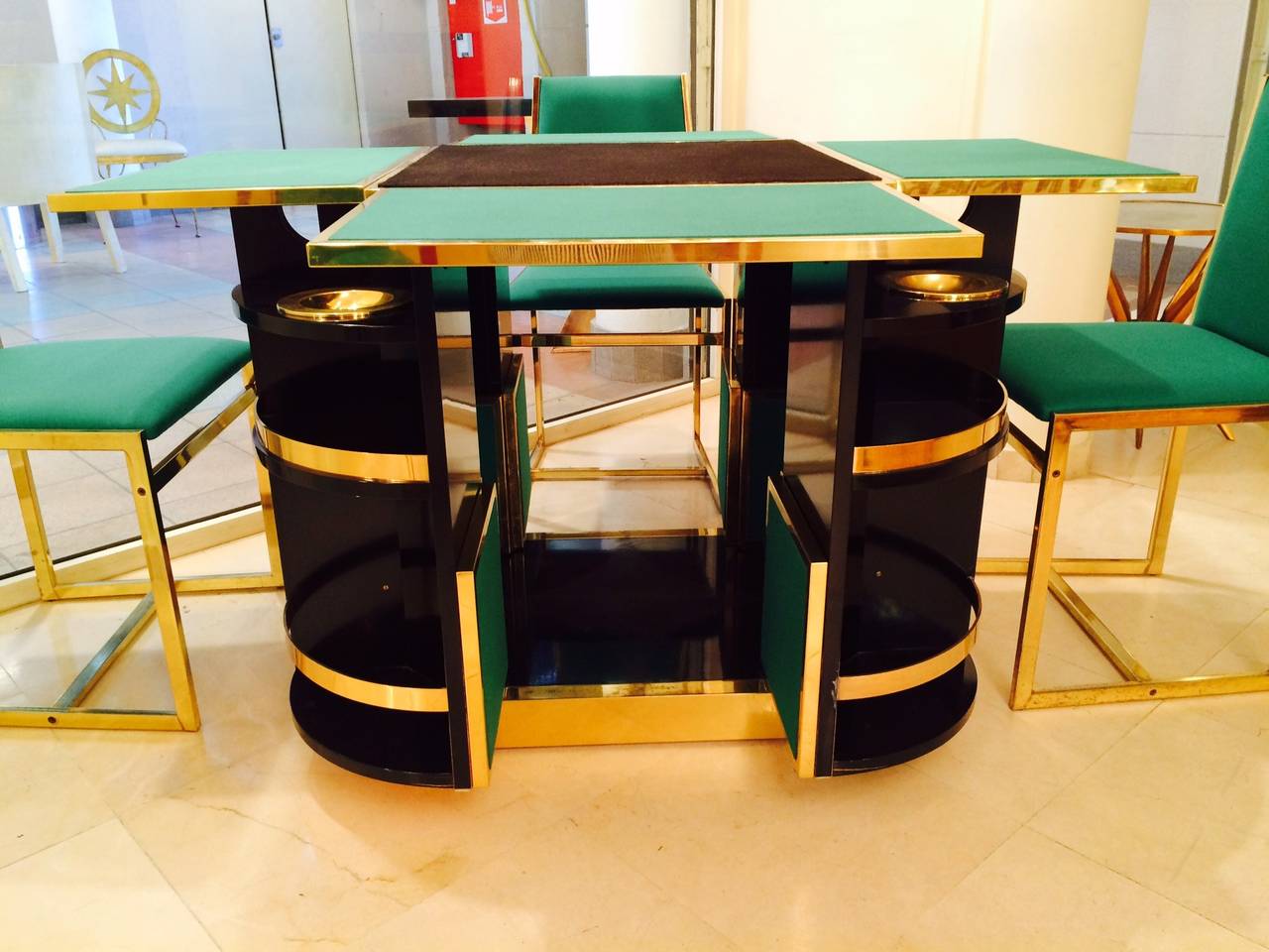 Extraordinary set signed Moneybello made during the 1970s.
The game table can be closed to form a cube.
Made in wood, bronze, green fabric and black lacquer
for each game player, there is shelves for glasses and bottles.
Four chairs in gilded