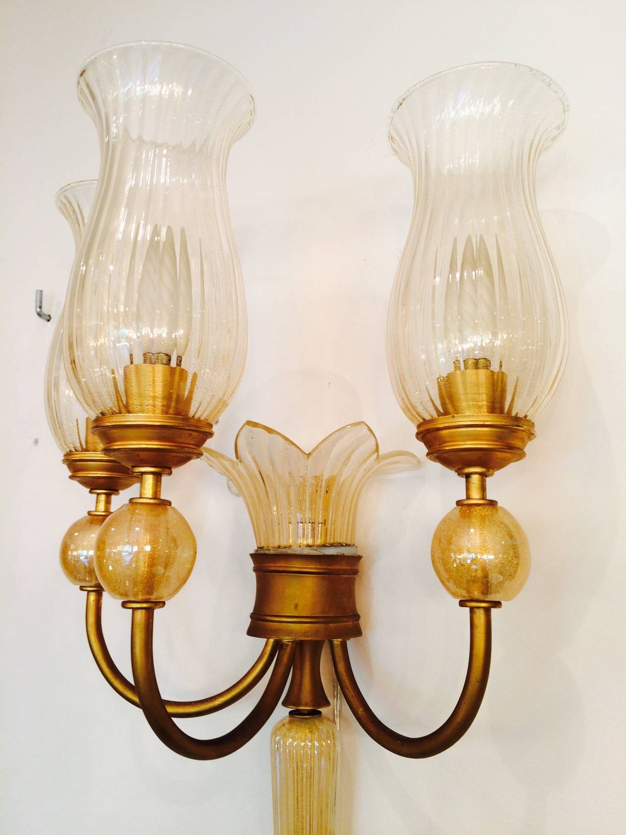 Very rare set of four sconces with three arms by André Arbus designed for Maison Veronese, Paris.
Gilded metal and Murano gold inclusion glass.
This exceptional set is part of a bigger set including a big chandelier and two other
sconces with