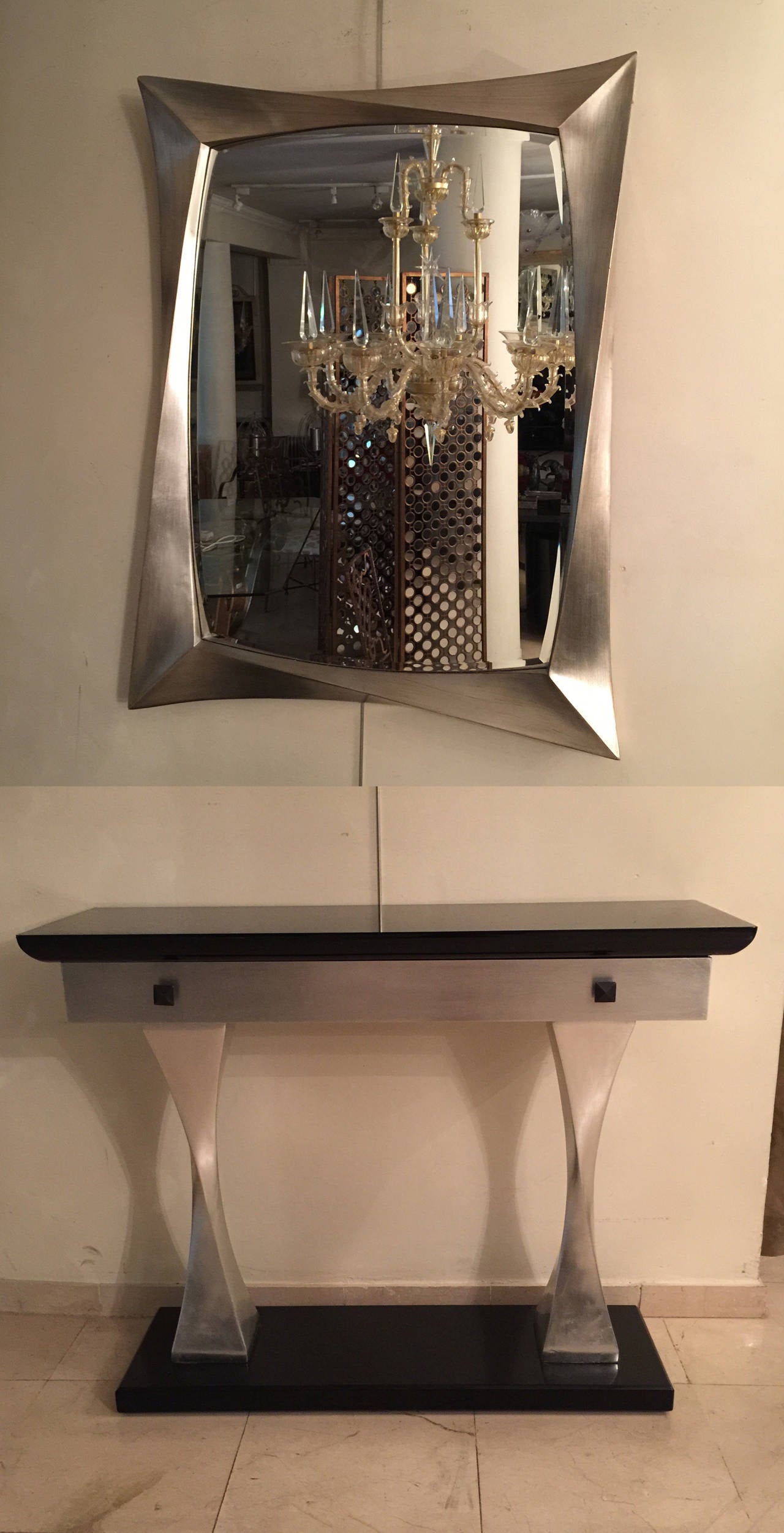 Black lacquer and silver leaf French 1980s set. Composed by a console and a mirror.
One-drawer on the front of the console.
The measurements of the mirror are:
110 cm/ 86 cm.