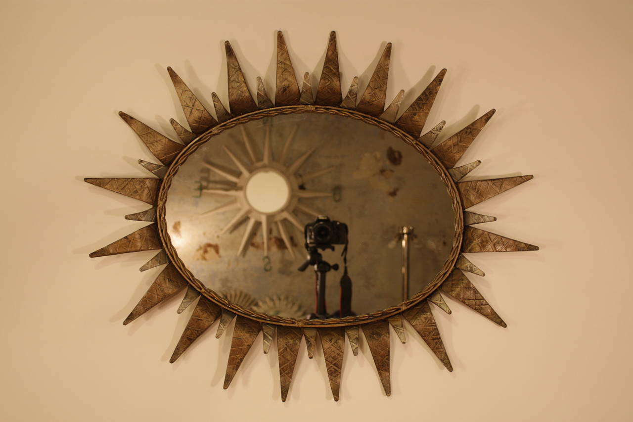 Oval gilt and plated sunburst mirror.