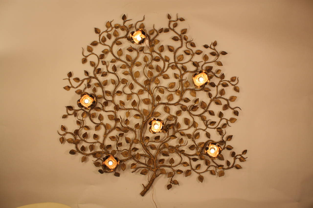 Large gilt iron ornate tree wall sconce with six flower lights.
