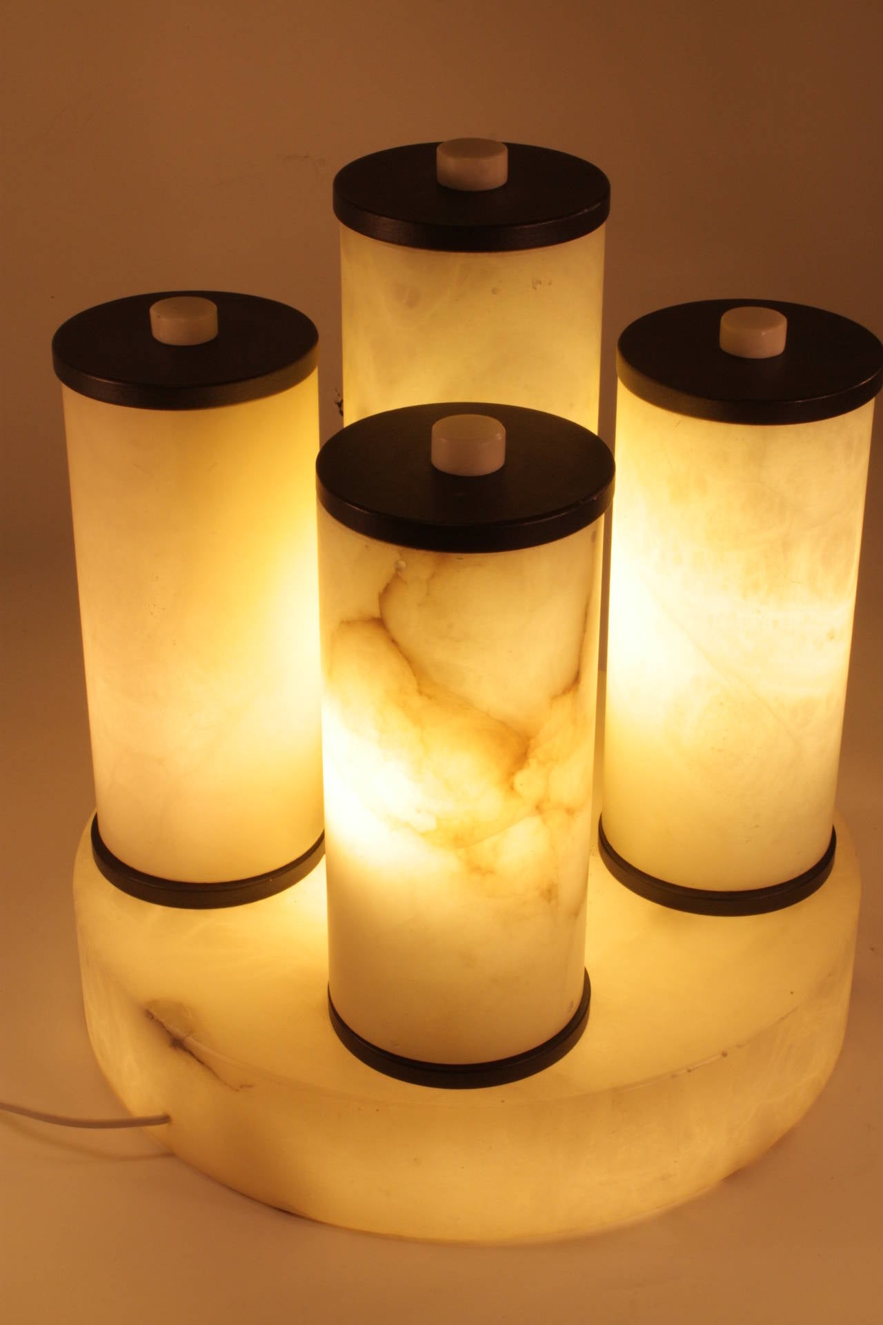 Bauhaus style design alabaster cylinders lamp, five alabaster cylinders with light, the base has also light. Top and bottom black pieces of resin. Top button pieces of alabaster. Six bulb, new rewired.