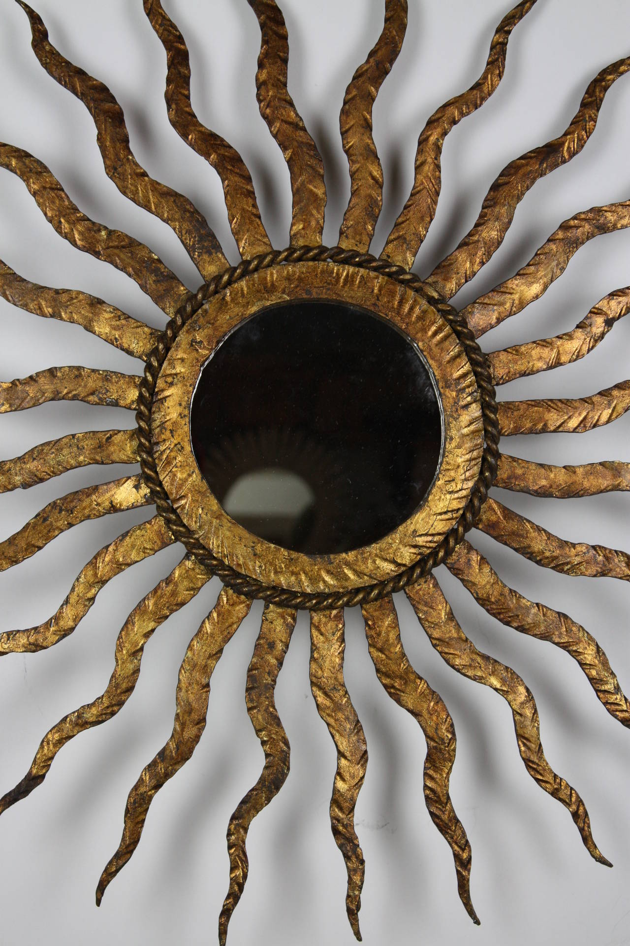 Gorgeous sun mirror in gold leaf gilt iron. Beautiful original patina.