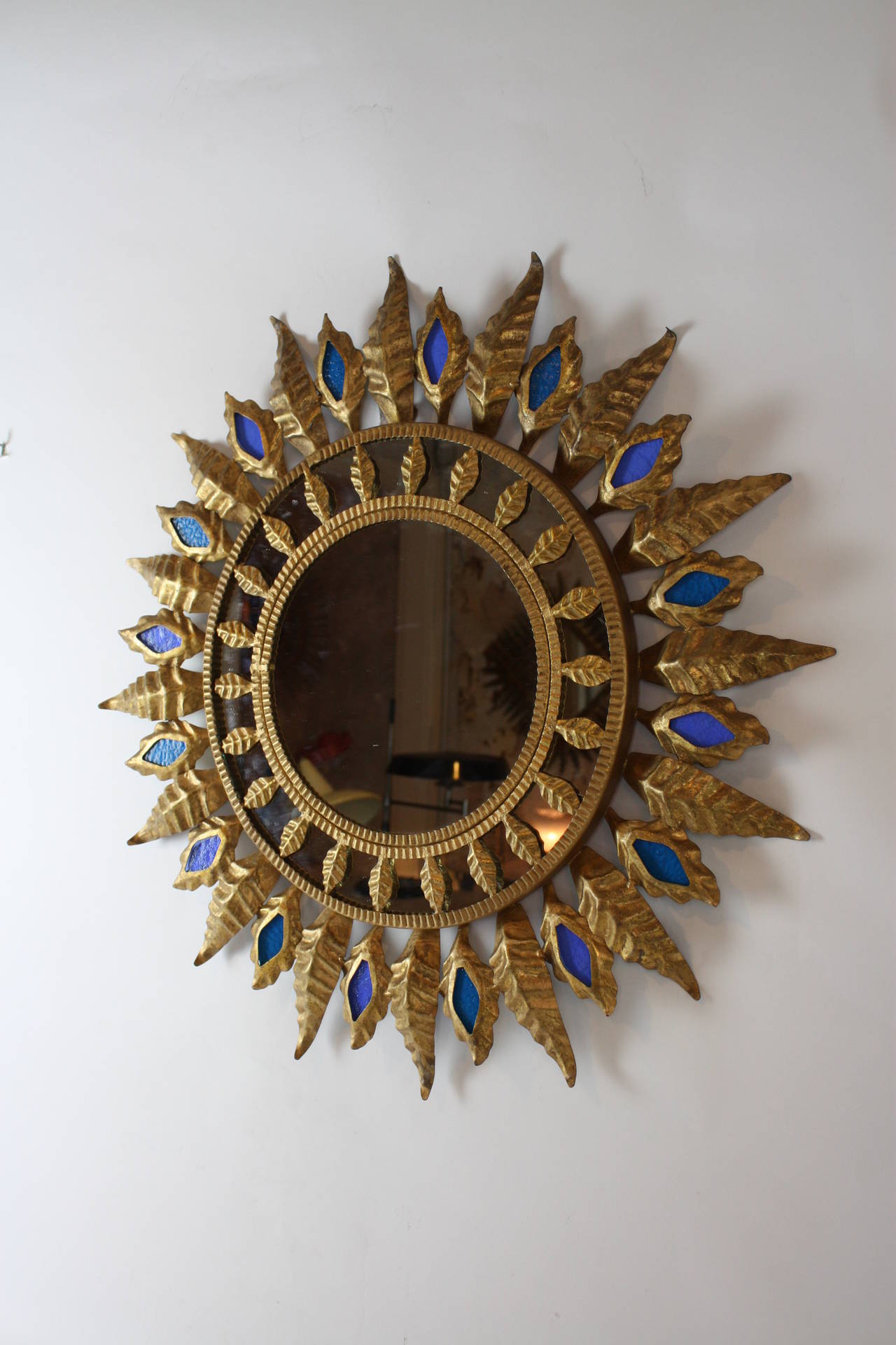 Mid-Century Modern Gilt iron sunburst mirror with blue glasses