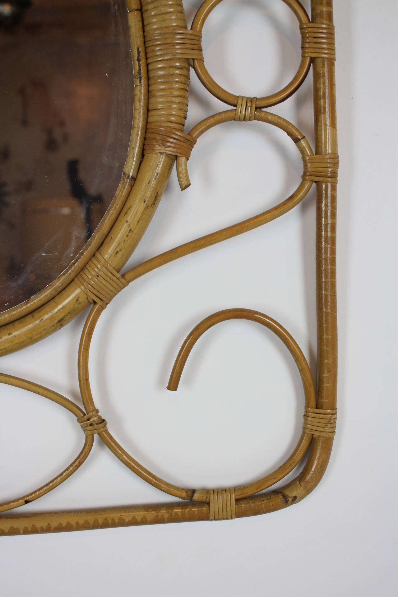 Artistic frame made with handcrafted rattan and surrounding an oval mirror