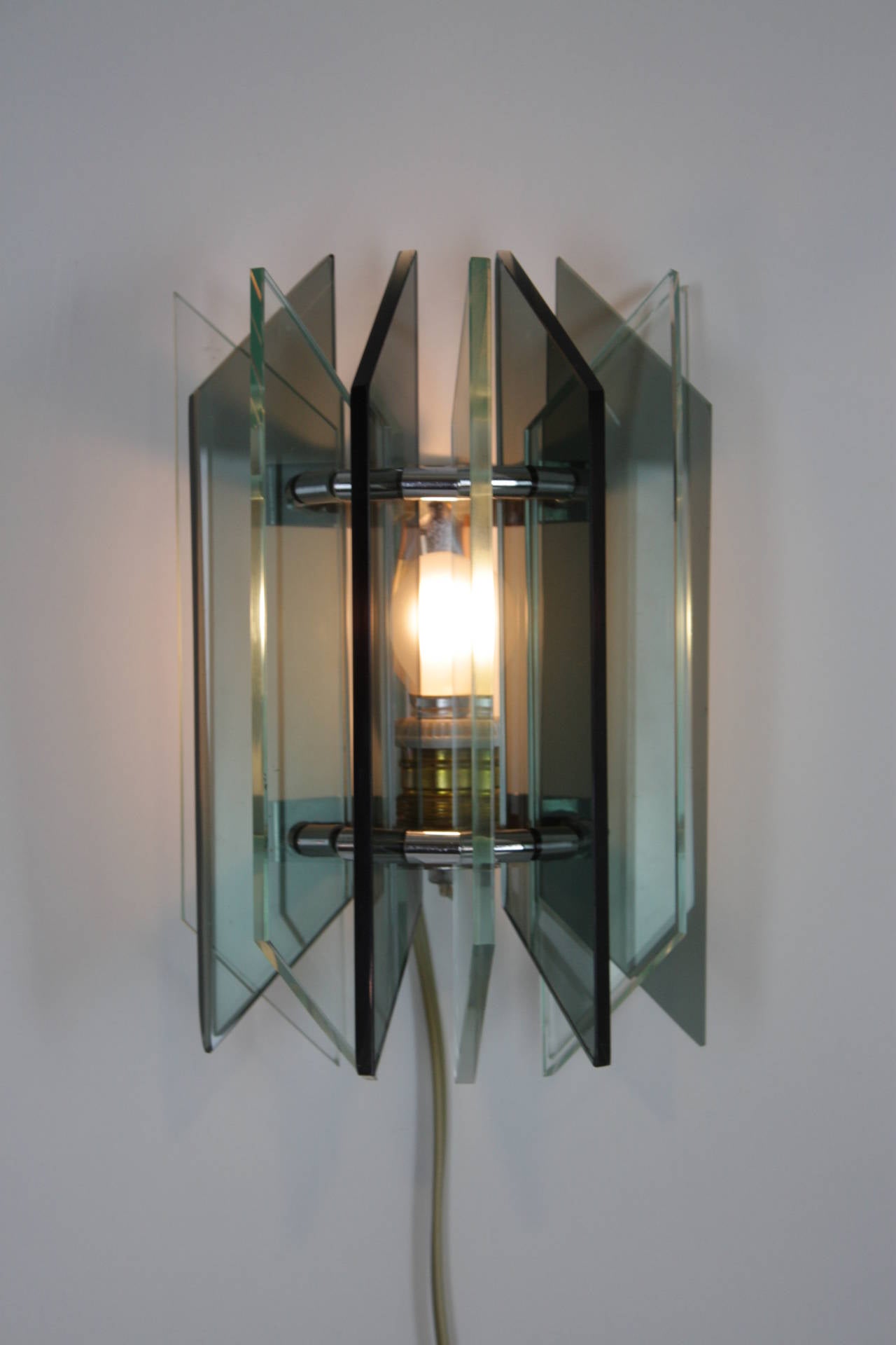 Pair of glass sconces with alternating smoked and clear glass pieces in a beautiful distribution on a chromed steel base.
Italy, 1960s.