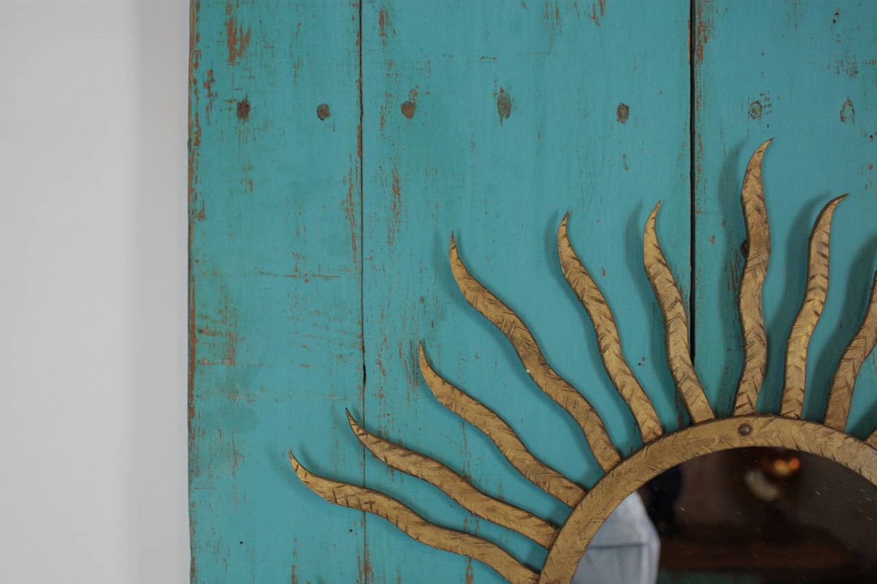 An Spanish gilt iron sunburst mirror from the 1950s in the style of Poillerat framed on an early 19th century turquoise door with beautiful patina that has a cat door at the bottom.
We have made a contemporary composition at our atellier with