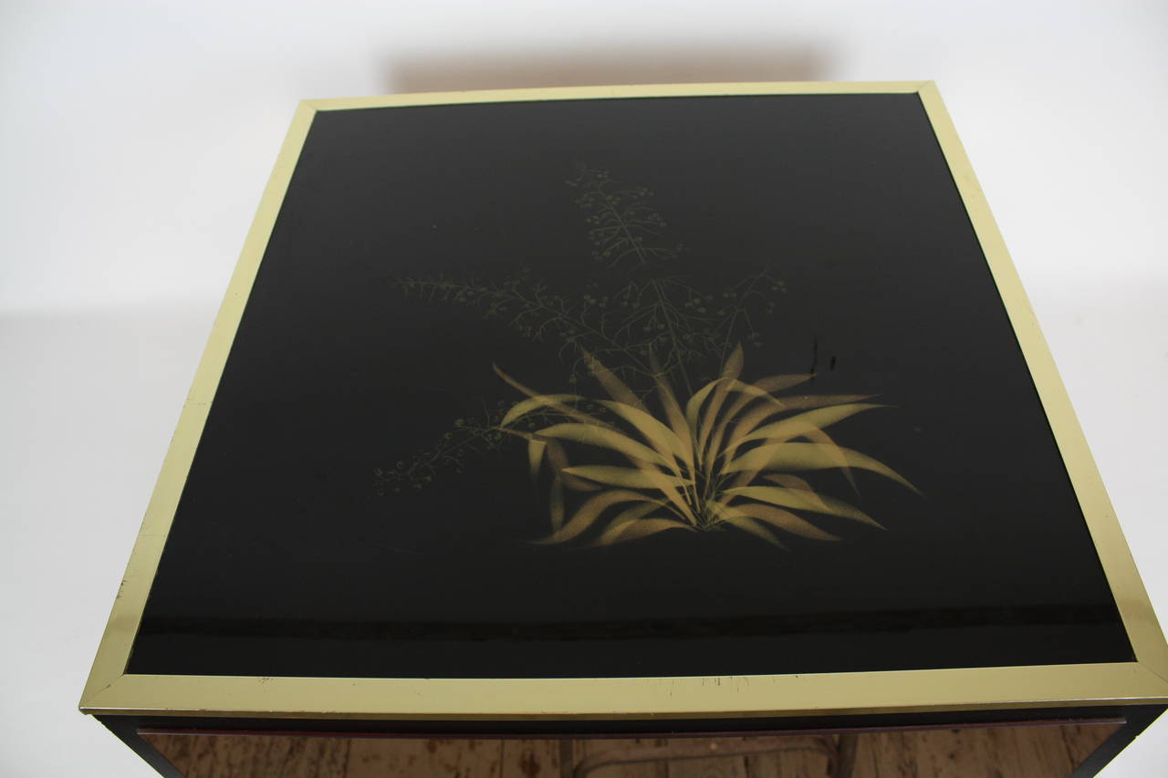 Beautiful coffee table from the 1970s. Made in lucite, wood and brass. A black glass top with elegant plants details painted in gold color.
Four lateral pink mirrors.