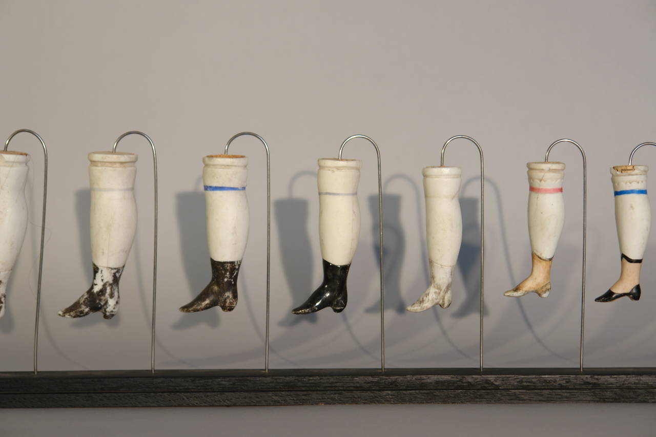 A collection of 19 French Porcelain Doll Legs mounted on 3 stands In Good Condition In Antwerp, BE