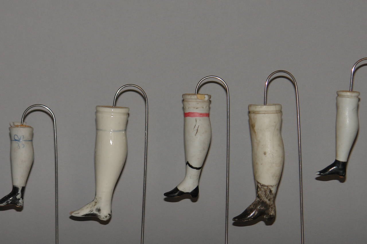 A collection of 19 French Porcelain Doll Legs mounted on 3 stands 2