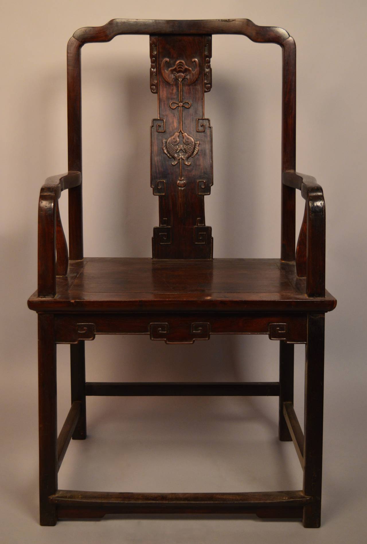 19th century Chinese armchair having a back splat carved with two important Chinese symbols; the bat 