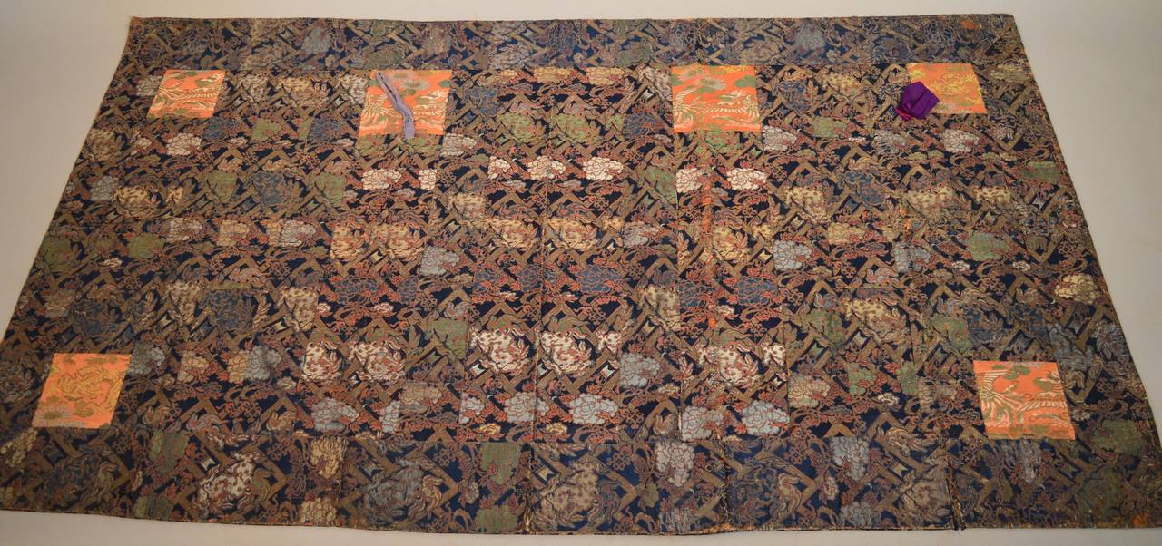 A Japanese silk & cotton brocade Kesa Buddhist Monk's robe circa 1890-1900. Kesa are made of patches of fine textiles donated by patrons and deciples of the monastary. These pieces would be sewn together by the monks as a meditative art and used