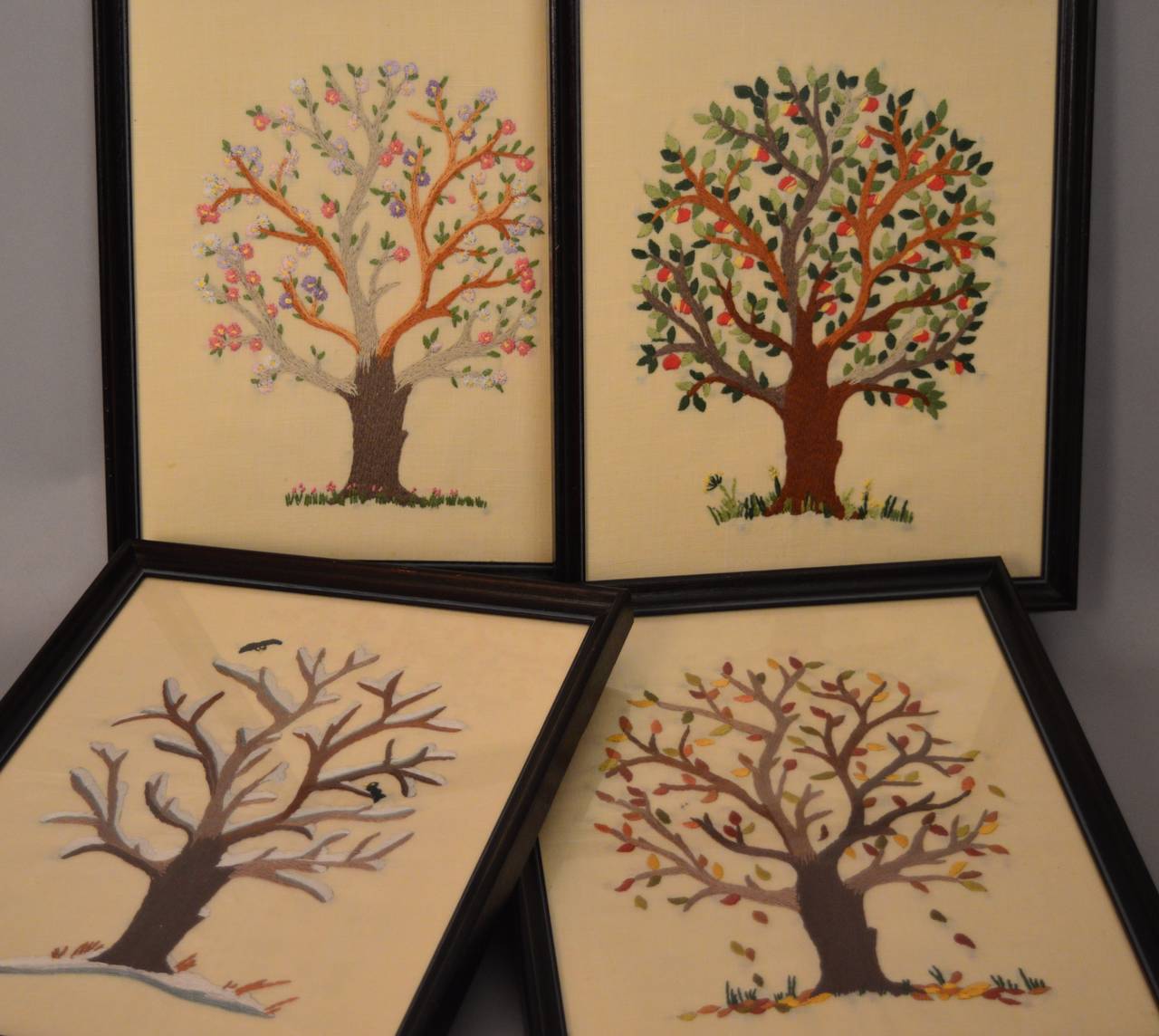 A series of four hand embroidered panels depicting the four seasons circa 1940 Belgian. Each panel is finely embroidered in wool on a cotton panel and retaining the original black wood frames.Beautiful graphic needlework in excellent condition.