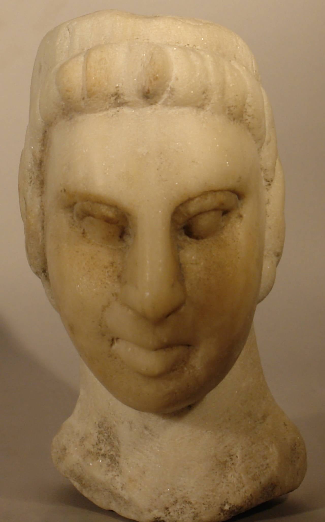 An elegant Northern Italian carving in white marble of an Etruscan noble woman’s head. Hand-carved in the style of an antiquity as was popular to purchase on a young mans 