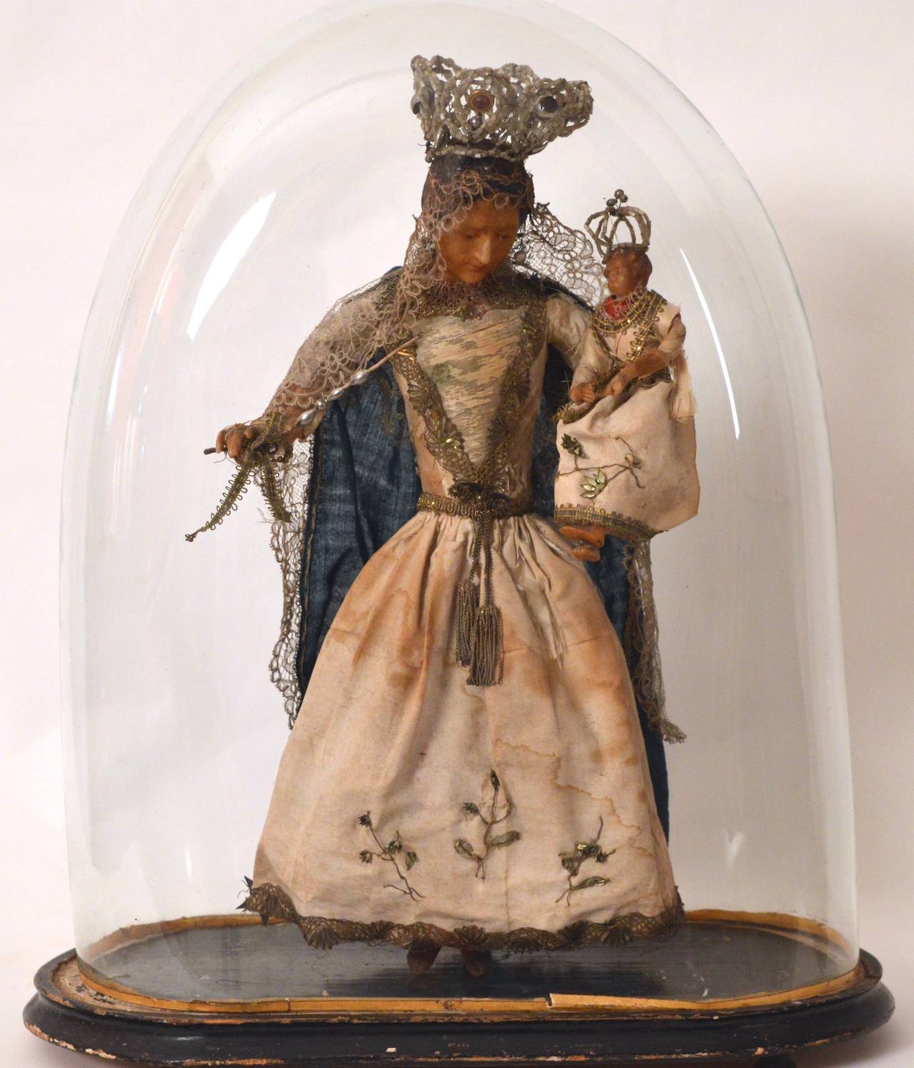 Exceptionally fine wax statue retaining the original costume in silk, cotton damask, belgian lace and glass beads. Covered with a 19th century glass dome for  dust protection.