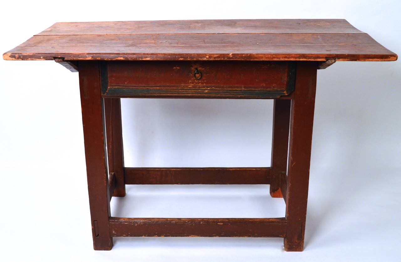 19th century Swedish one-drawer table. A very pure example retaining the original paint (initials and date of 1859) as well as the original hand-wrought iron drawer pull.The top is constructed from two wide plank boards and have a slight curve and