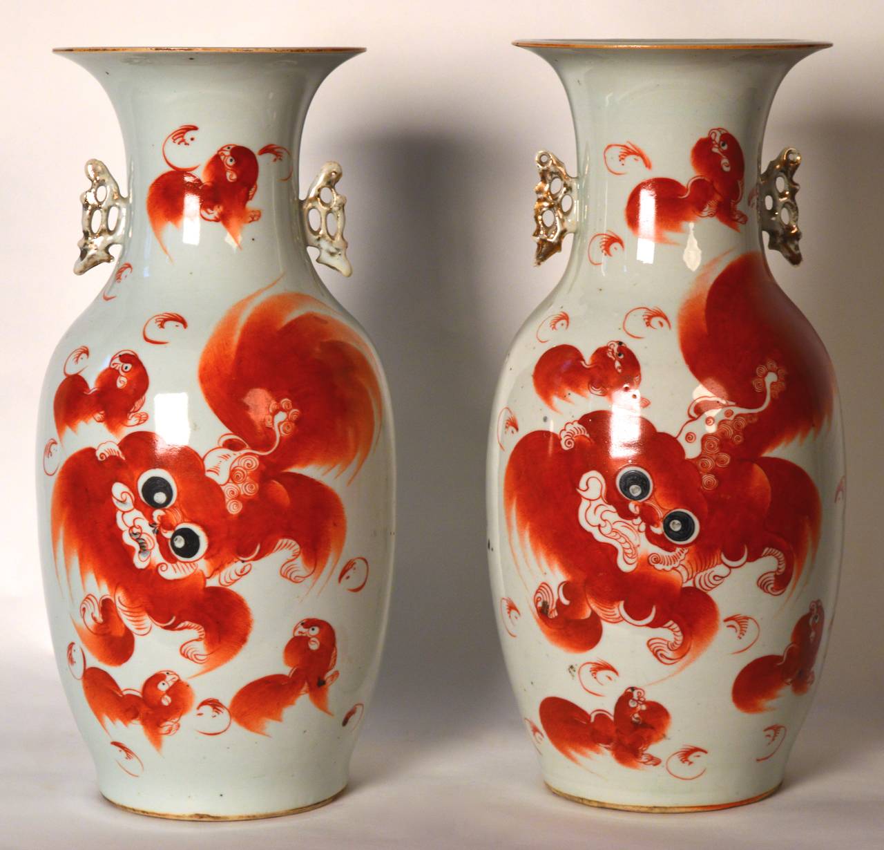 Two Chinese baluster form porcelain vases . White with iron red Shishi foo dog decoration on front , black good luck characters on reverse and gilt side handles.
Chinese Qing dynasty (end of the 19th century)
