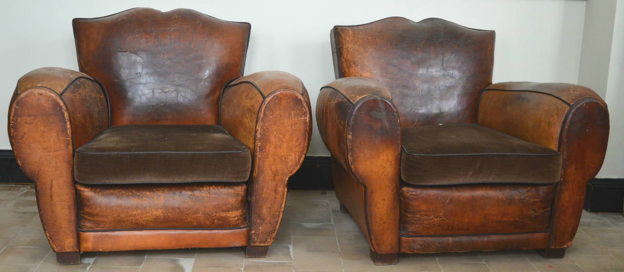 A pair of French leather club chairs with the perfect amount of patina to add an old world 