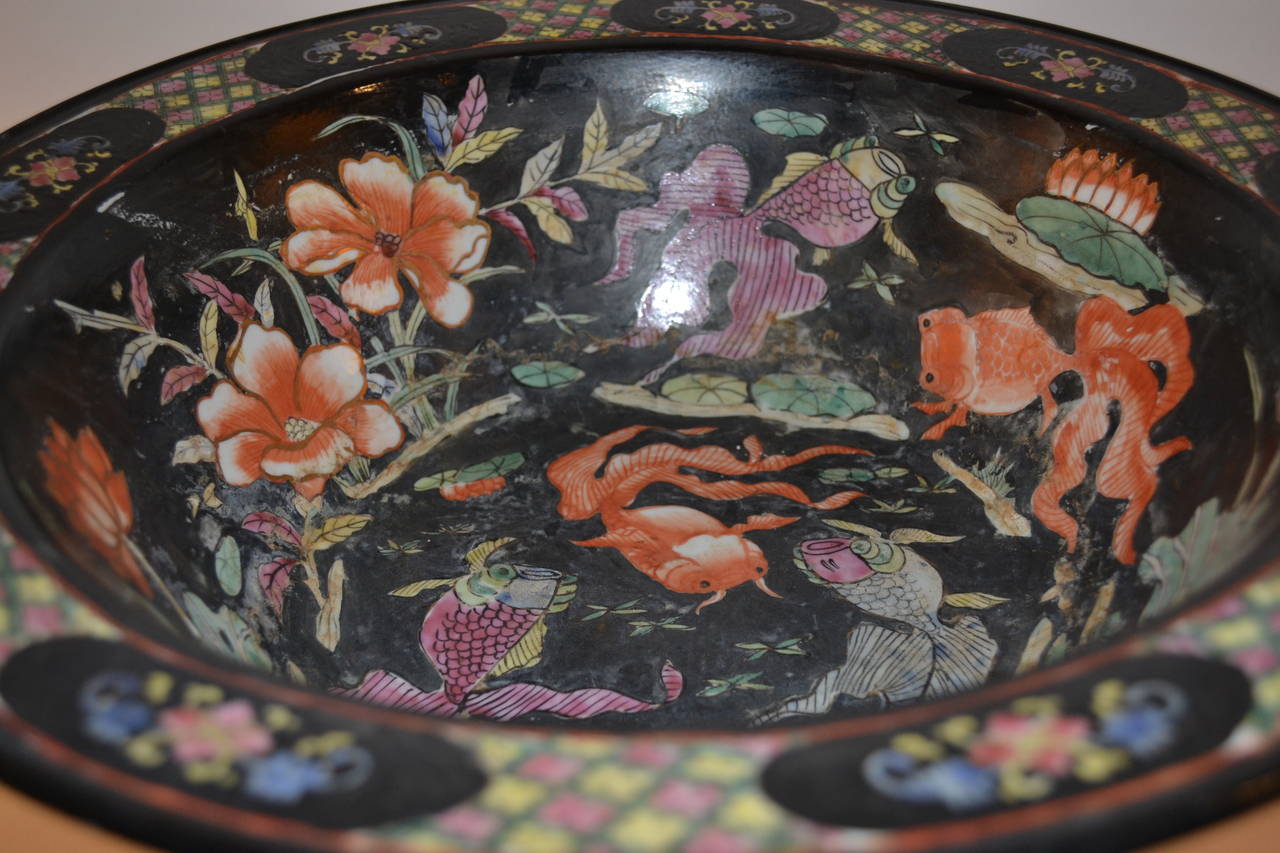 Colorful pattern with flowers leaves, geometrics and koi on large black lidded
bowl that rests on stand.

Bottom of bowl stamped.

Purchased from Maitland-Smith in 1981.