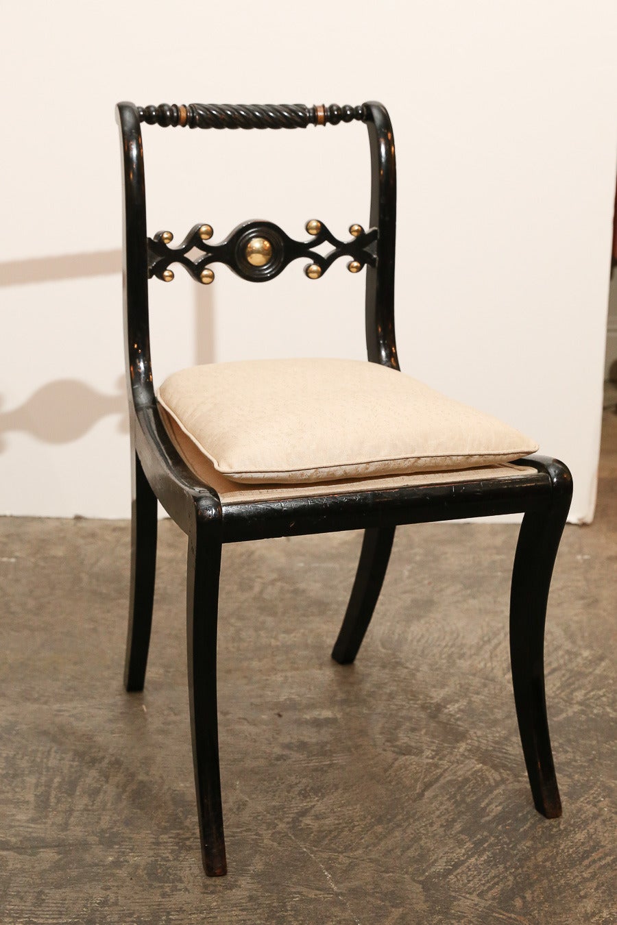 2 Arm chairs & 4 side chairs black Painted Regency dining chairs with interesting back splat design featuring brass studs.
Top rail of back has twisted wood pattern

Small scale, but comfortable.