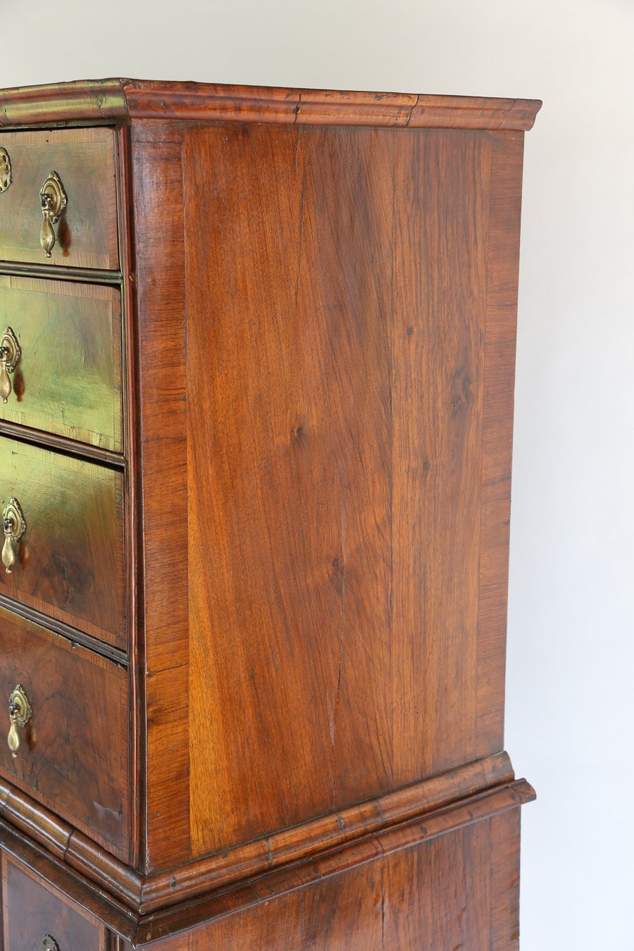 Antique English Queen Anne crotch flame walnut high chest, in two parts.

Upper section has a moulded Cornice over two short and three long drawers,
with crossbanded inlay with all matching panels.

Lower section with three drawers on a shaped