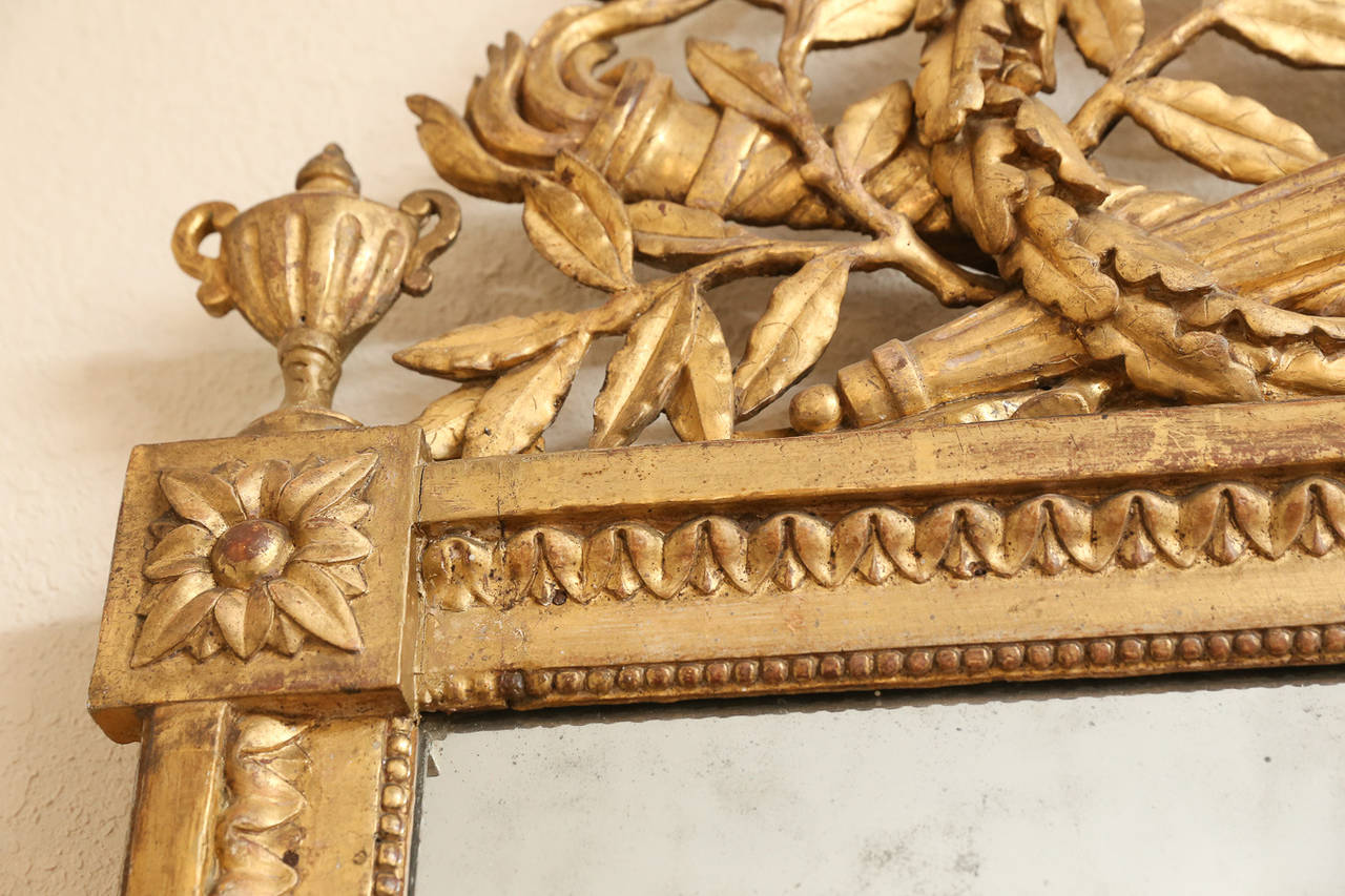 French Louis XVI period hand-carved neoclassical goldleaf
pier mirror containing original two-part glass with-in a bead molded frame. Crest is formed by a quiver of arrows crossed by a flambeau within 
victory and laurel leaves.

Top corners