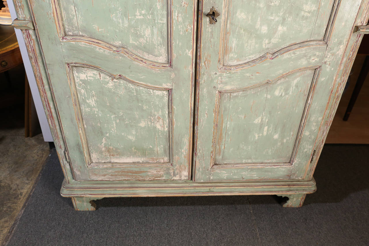 Soft Blue-Green painted and distressed Armoire with three panels on each door and block-paneled sides.

Crown has a wonderful shape.

Natural Walnut interior includes two shelves

Key included