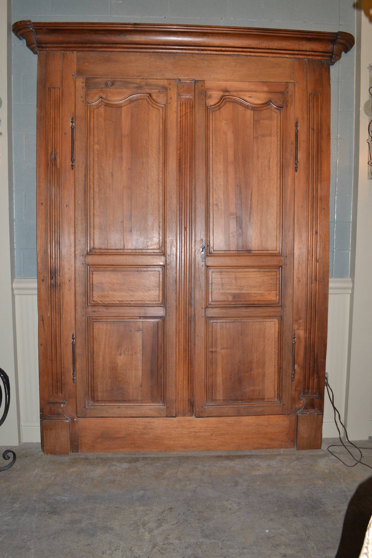 A pair of very tall armoire doors that include frame and crown.

Hinges and lock are original and have a working key.

Slightly raised side columns have fluting.