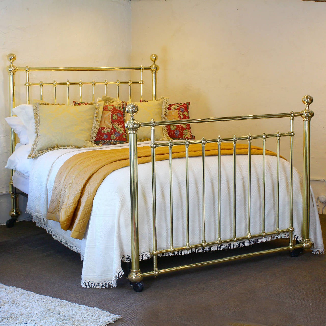 An elegant all brass bedstead in the British King Size (5ft x 6ft 6in) with substantial posts and brass collars and knobs, and simple ball shape fittings in the panels. The brass foot board has hidden fittings to the side irons allowing the covers