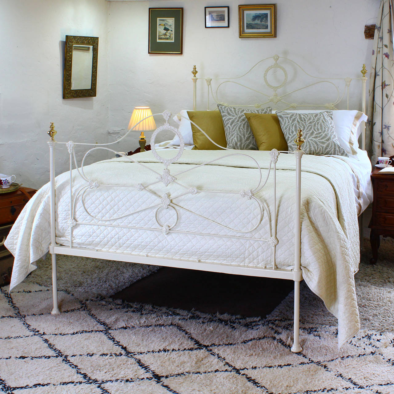 A fine example of a mid-Victorian cast iron and steel bedstead with decorative panels, featuring ornate castings including a central oval, and ornate brass knobs.

This bed accepts a British king-size (5ft wide x 6ft 6in long) base and mattress
