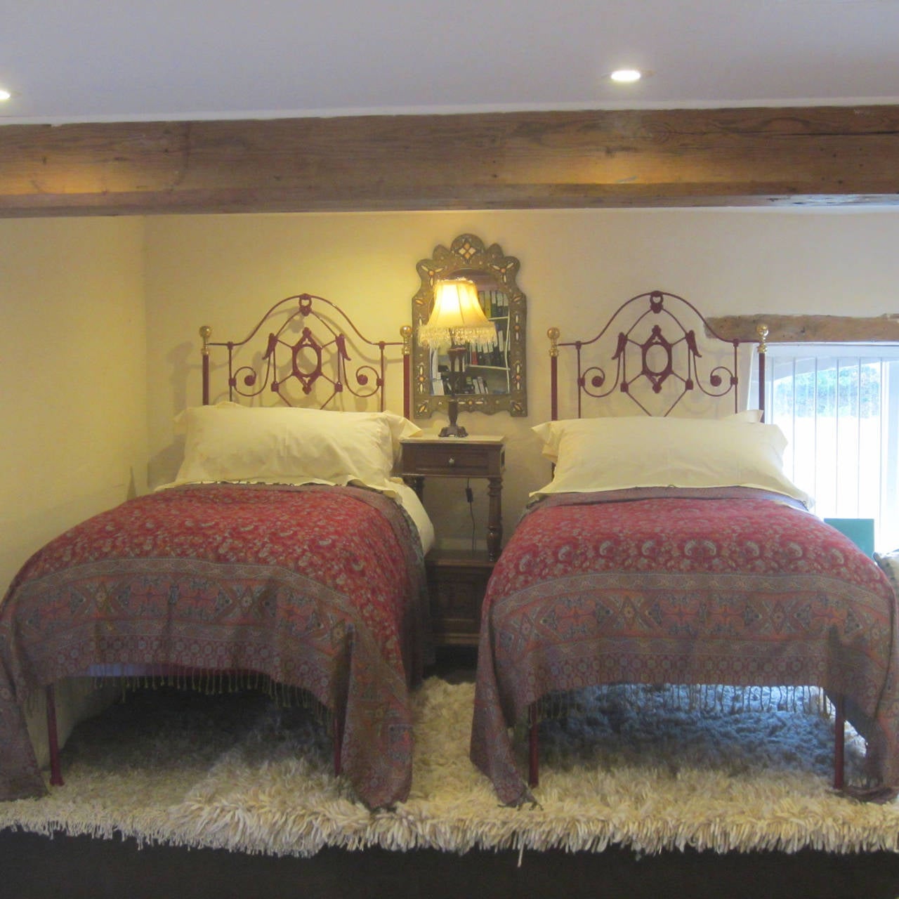 A pair of cast iron platform bedsteads with decoratively cast panels finished in hard-wearing powder coat red berry. These beds are low ended but still have the full frame to support a bed base and mattress. The knobs on the head panel are polished