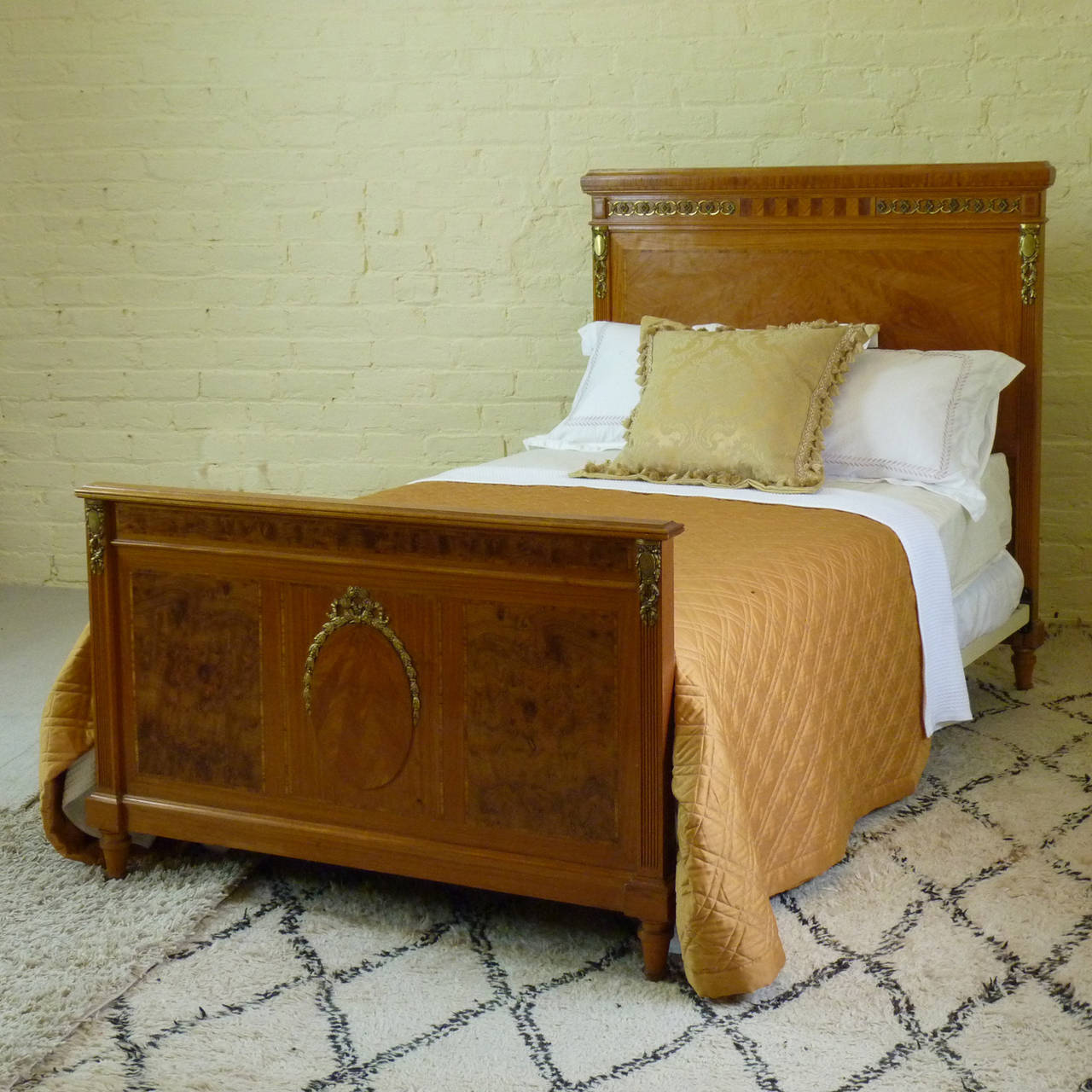 A matching pair of Empire style twin beds in the 4 ft width. Early 20th century style with magnificent parquetry work in the head panel. The foot panels feature a central oval plaque with a 'sunburst' design with ormolu ribbon garland, flanked by