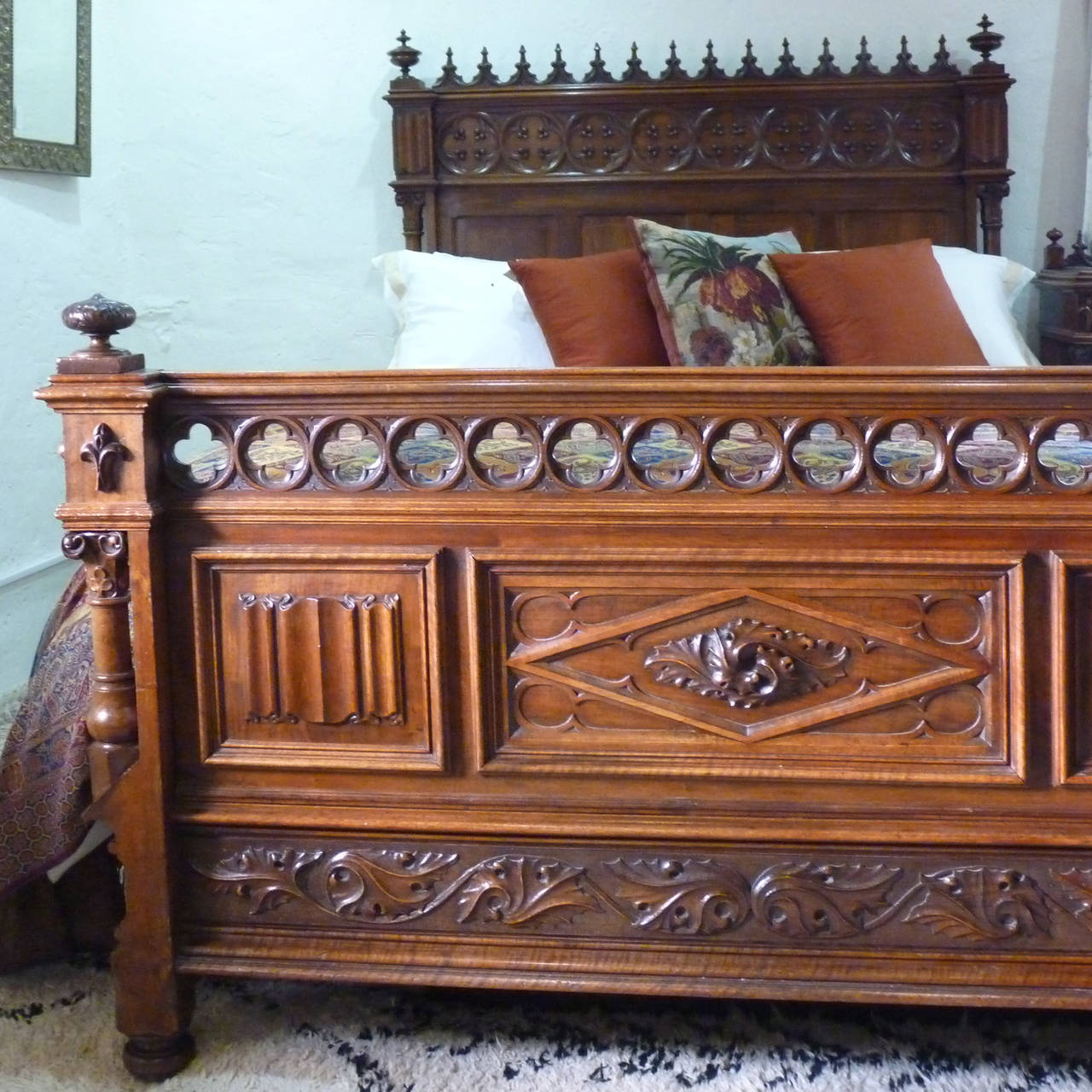 This fabulous Gothic inspired bed has superb carving in the head and foot including linen folds, fleur de lys and quatrefoils, typical of the style. The architectural form is emphasised by the column posts, the cut-out quatrefoils in foot board and