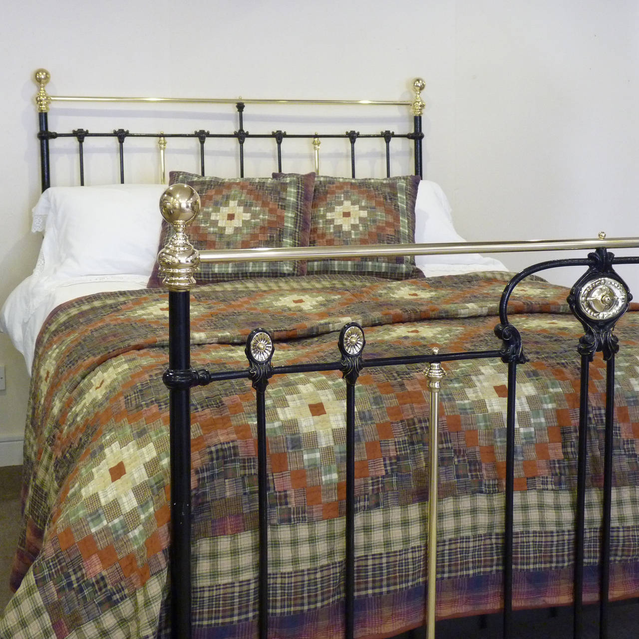 This fine bedstead finished in black has Art Nouveau style design in the foot board with large central rosette, decorative mouldings and smaller rosettes, which stand proud of the castings.
The castings in the head and foot panels have faded gold