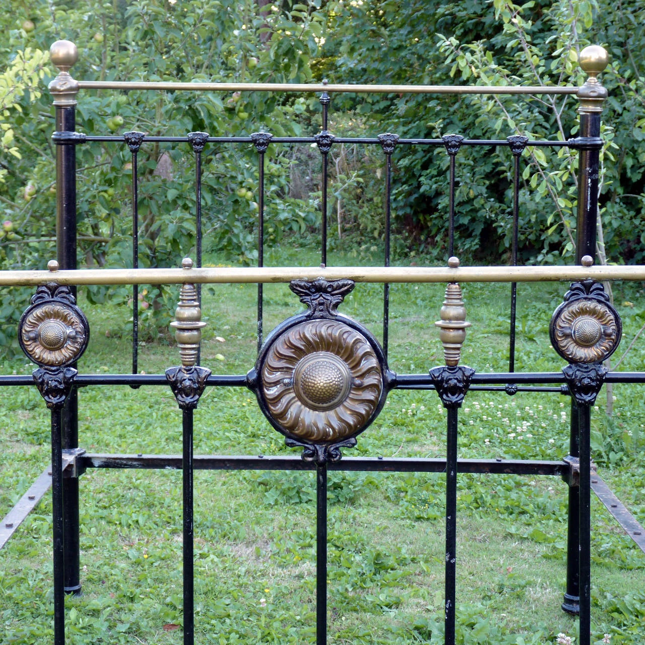 A decorative brass and iron bed with superb brass rosettes depicting large sunflowers.

This bed is shown here in its original condition. Currently the width is a Standard British Double at 54 in. (135 cm). However we can widen and lengthen the