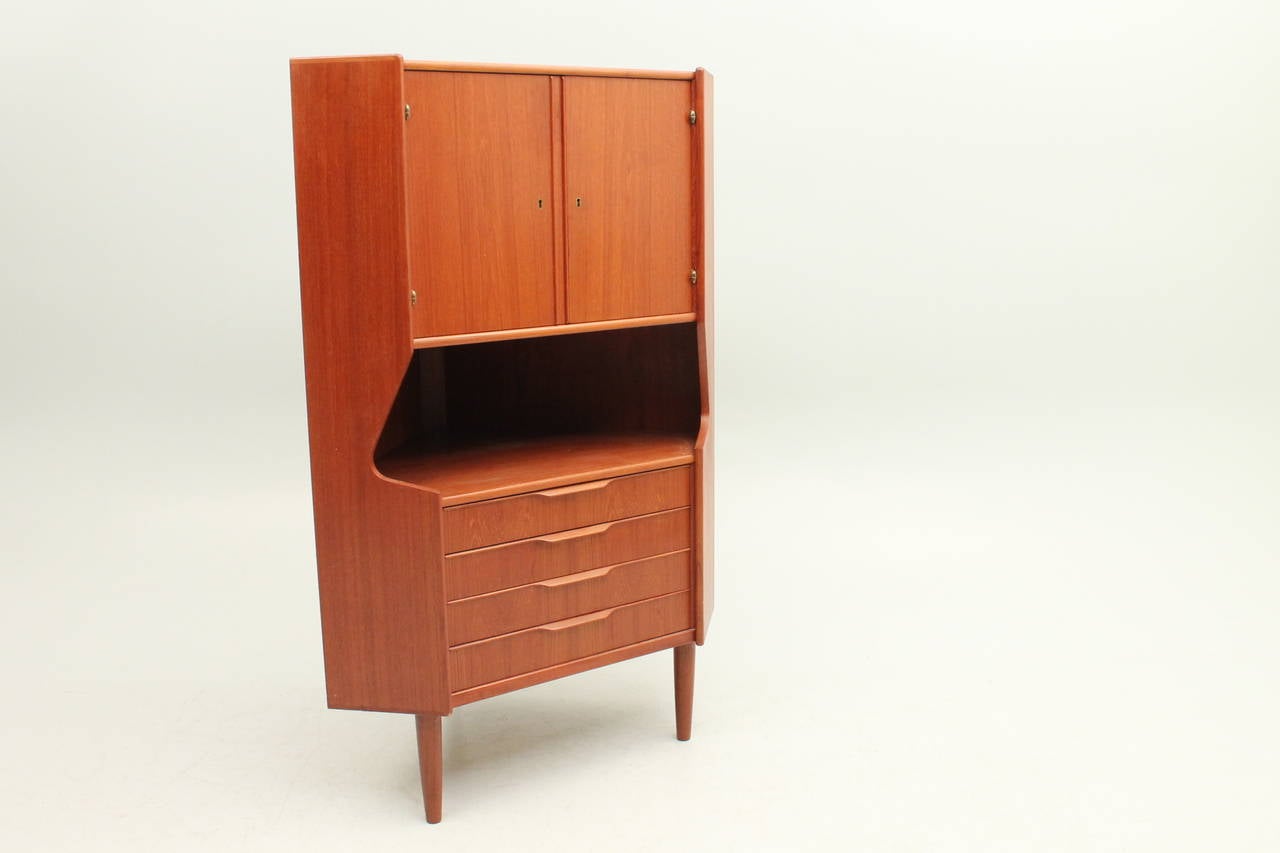 Stunning mid century modern corner cabinet designed by Johannes Sorth for Nexø Møbelfabrik. This piece is perfect for serving, it would make a fabulous a bar, or storage in a small space.