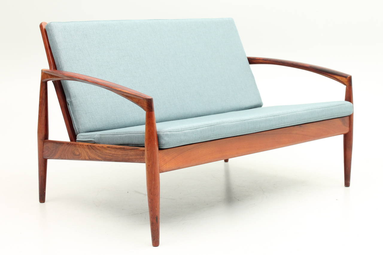 Absolutely stunning rosewood sofa designed by Kai Kristiansen for Magnus Olesen. Recently reupholstered with original tags intact.