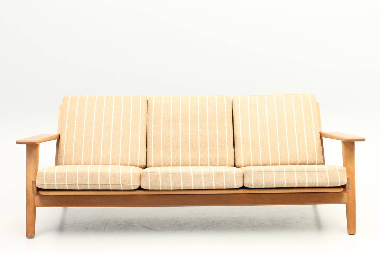 Newly reupholstered sofa by Hans Wegner for GETAMA. This item is part of an entire set (sofa, low chair, high chair and stool). There is a 10% discount for purchasing the entire set as we hate to see it broken up.