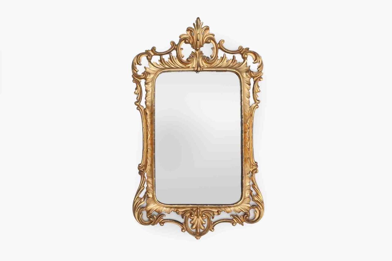 19th Century giltwood mirror. The pierced crest with c-scrolls. The mirror plate flanked by carved acanthus with c-scroll apron.