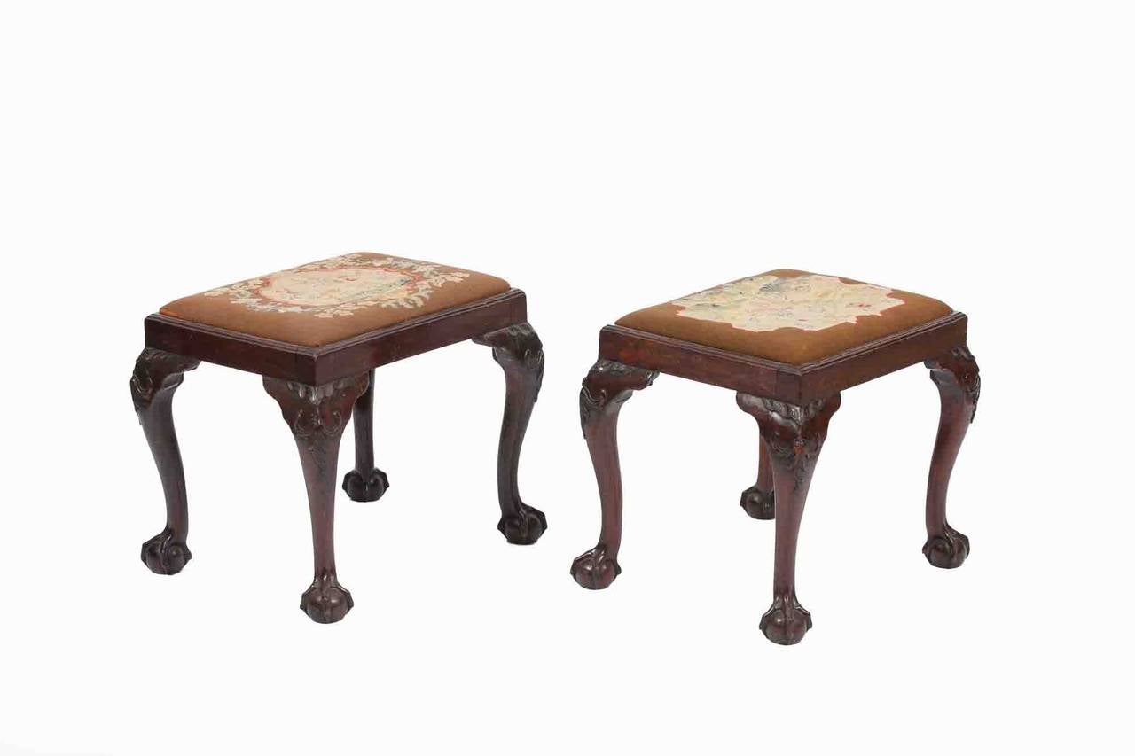 Early 19th Century Irish Mahogany Stools, the drop in seats above rectangular frames with acantuhus leaf carved cabriole leges on ball and claw feet, circa 1820.