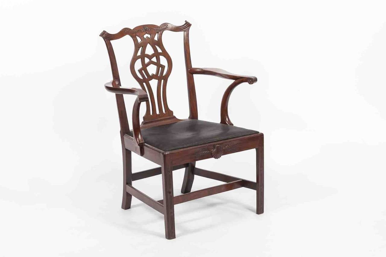 18th Century Irish George II mahogany carver, the bow shaped back rail centred with flowerhead motif flanked with scrolling acanthus leaf and moulded corners raised over pierced interlocking back splat above curved outswept arms with opposing