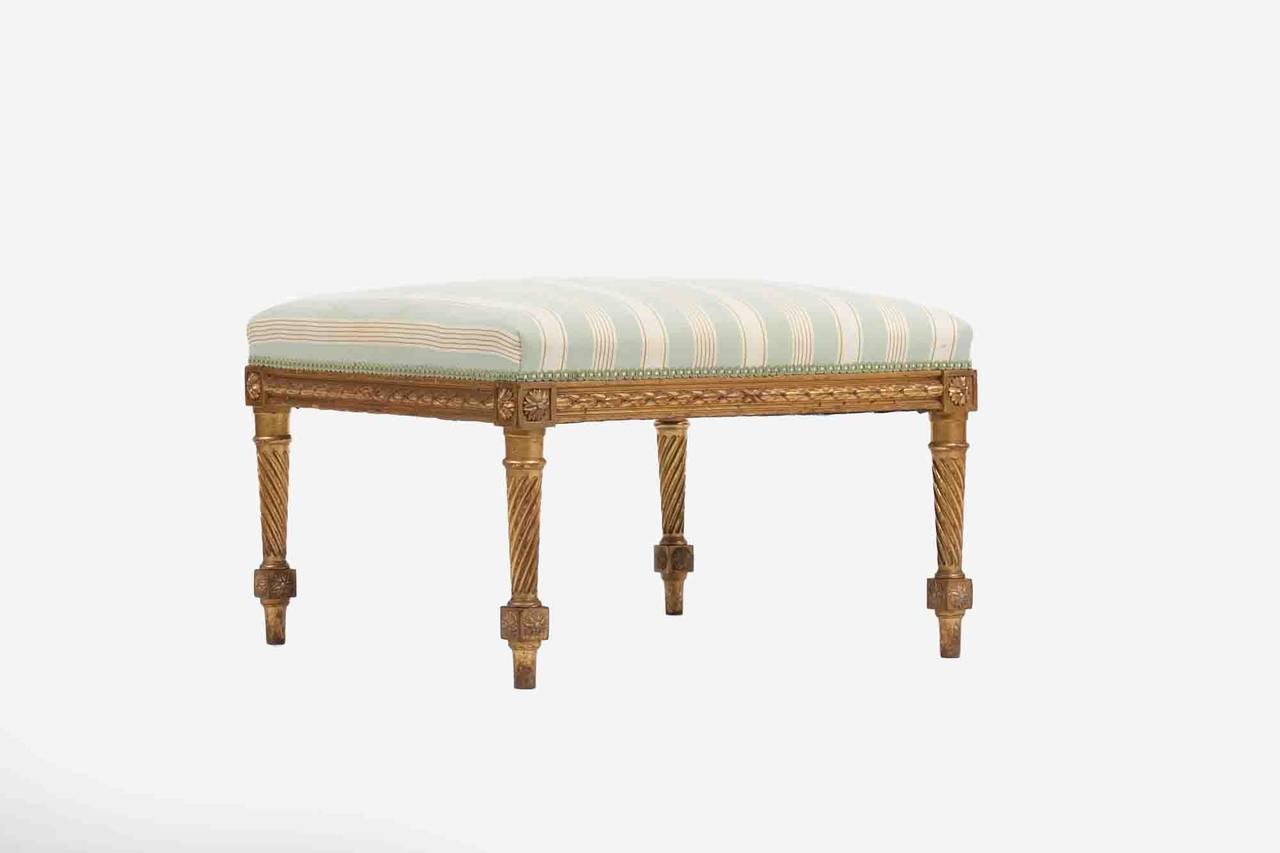 Early 19th Century giltwood stool.  The stuffover seat above tapered scroll legs.