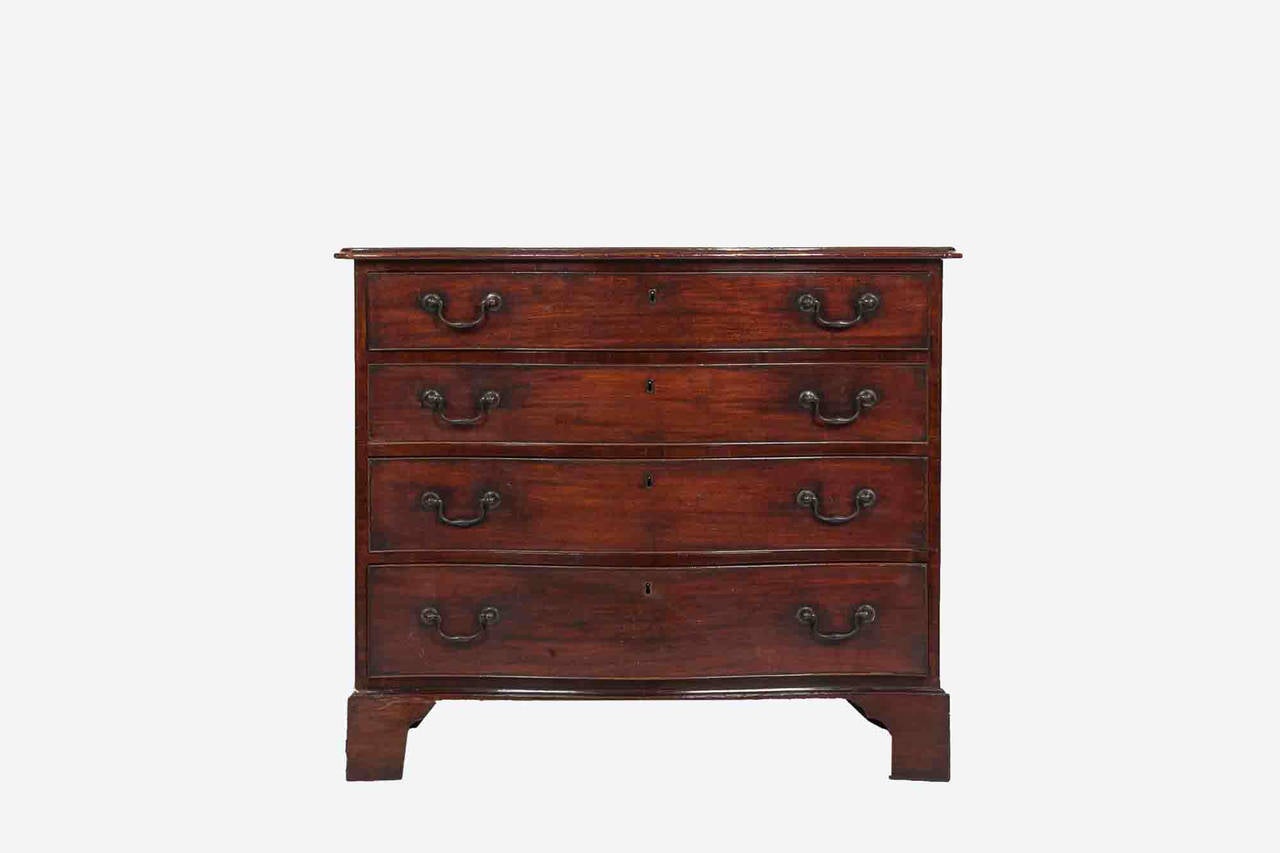 18th century Irish George III period serpentine fronted chest of drawers.  This gentleman’s Bachelor’s Chest is so called because it features full toilette drawers beneath a sliding desk, the top drawer is fitted with mahogany linings.  Lovely