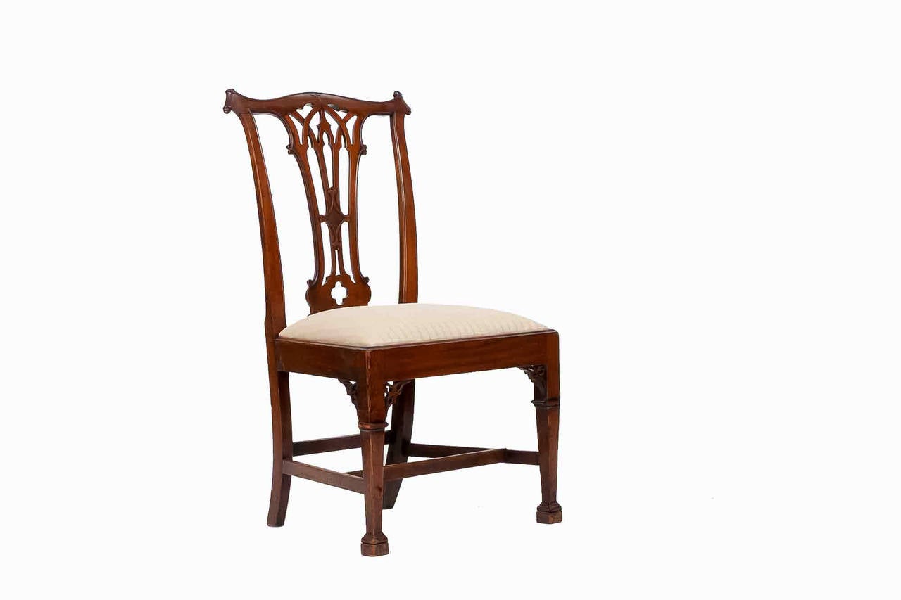 Sechs Esszimmerstühle im gotischen Chippendale-Stil aus dem frühen 19. Jahrhundert mit fein geschnitzter Rückenlehne. Die Sitze sind cremefarben gestreift und gepolstert. Das führt zu fein geformten Beinen und Füßen.