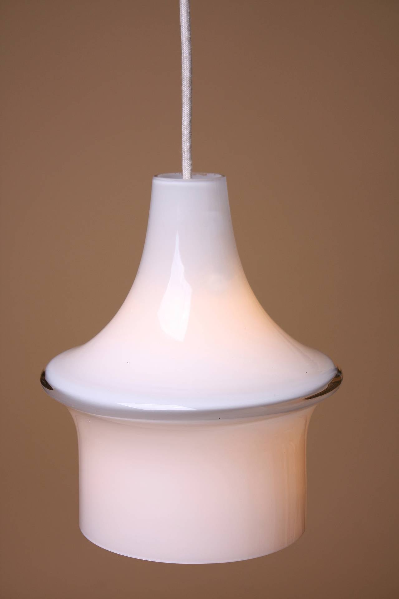 An opaque glass bell shaped pendant by Lisa Johansson-Pape, circa 1960. Beautiful example of Danish Mid-Century design. The pendant has been newly rewired on three feet of canvas cloth cord.